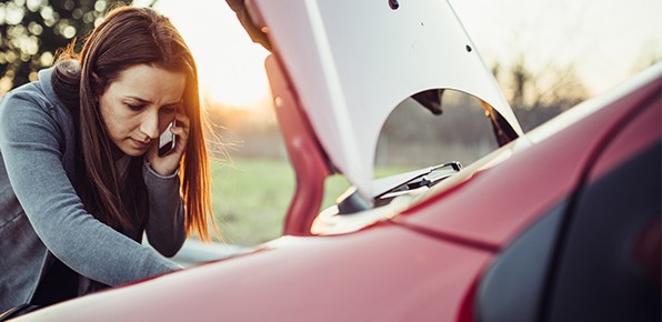 Female-Driver-On-Phone-Inspecting-Car-Engine