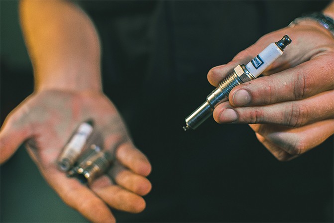 Mechanic-Holding-Champion-Spark-Plugs